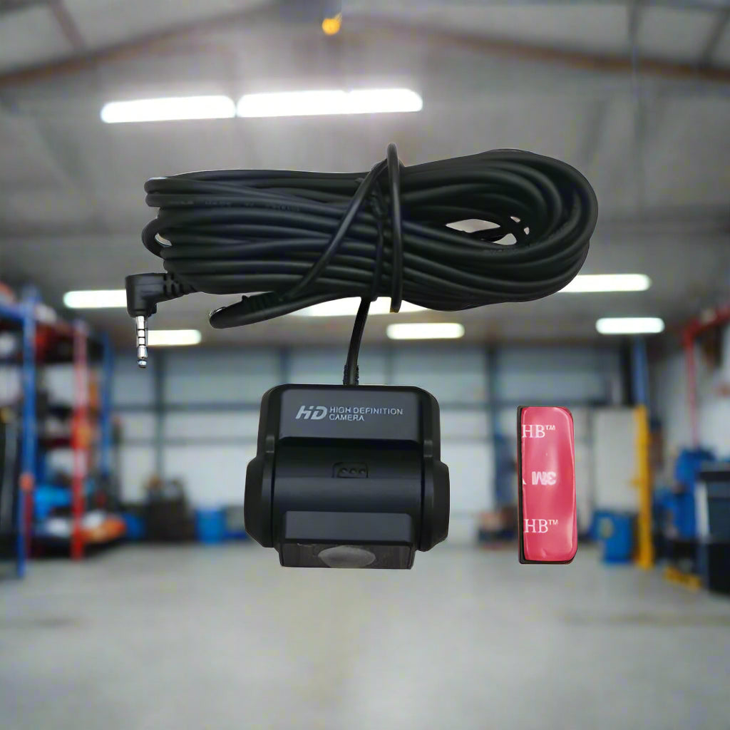 Car camera with cable and small red device on a white background