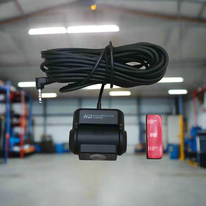 Car camera with cable and small red device on a white background